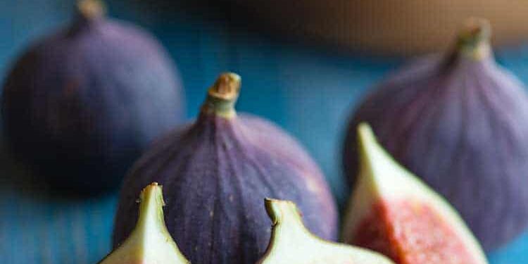 feigen Aufgeschnittene und ganze Feigen auf blauem Tisch