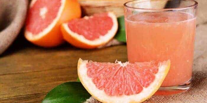 grapefruit1 Eine Scheibe Grapefruit neben einem Glas frisch gepresstem Grapefruitsaft