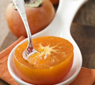 Halbierte orangefarbige Kaki mit Löffel