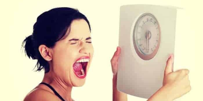 Frau schreit Waage an