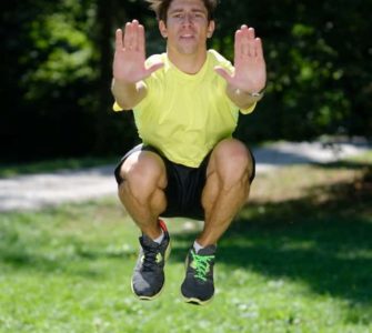 Mann macht Tuck Jumps im Park
