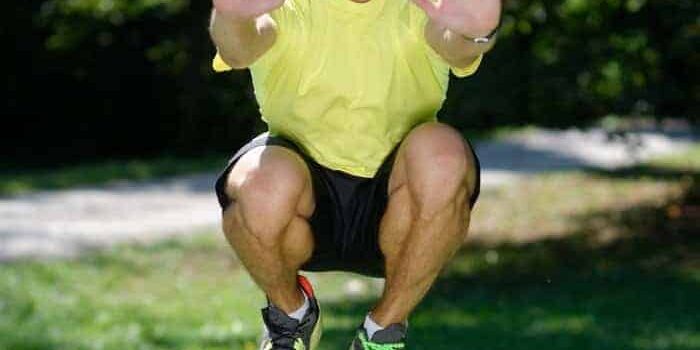 Mann macht Tuck Jumps im Park