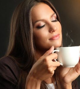 Frau riecht den Duft des Kaffees