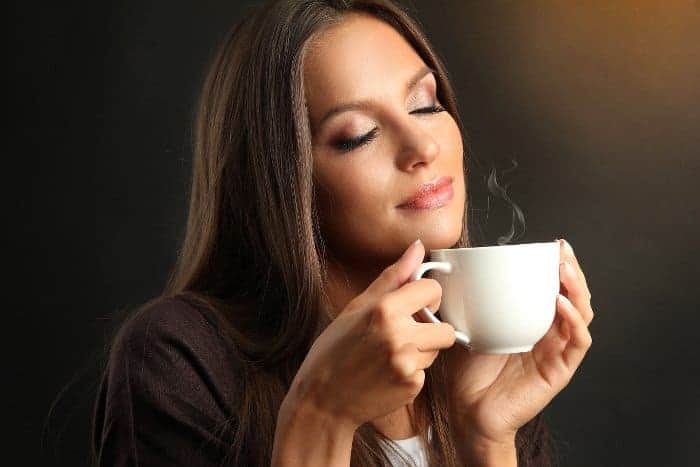 Frau riecht den Duft des Kaffees