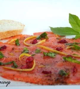 Lachscarpaccio mit Granatapfelkernen, Zesten einer Zitrusfrucht und Basilikum