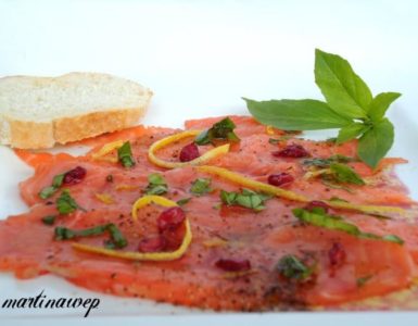 Lachscarpaccio mit Granatapfelkernen, Zesten einer Zitrusfrucht und Basilikum