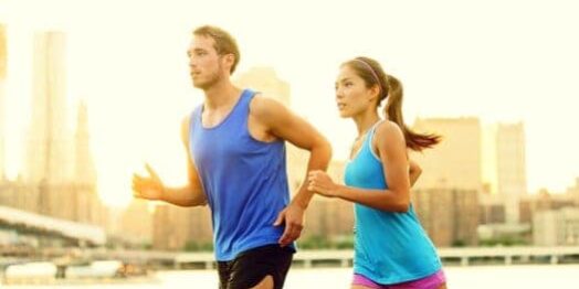 Training Junger Mann und junge Frau mit blauen T-Shirts joggen nebeneinander mit optimalem Trainingspuls