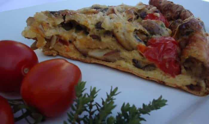 Eierkuchen mit Pilzen und Tomaten serviert auf weißem Teller