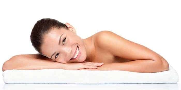 Frau liegt auf einem weißen Handtuch