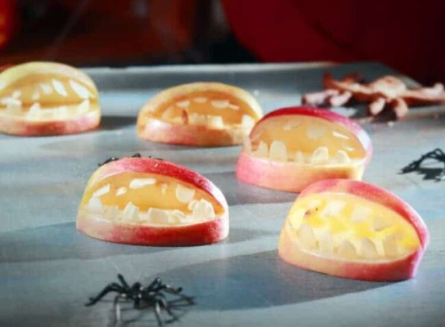 Geviertelte Äpfel, aus denen Apfelgebisse geschnitzt wurden