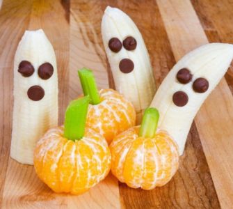 Bananen und Mandarinen verziert mit Rosinen und Staudensellerie