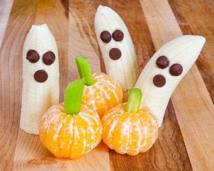 Bananen und Mandarinen verziert mit Rosinen und Staudensellerie