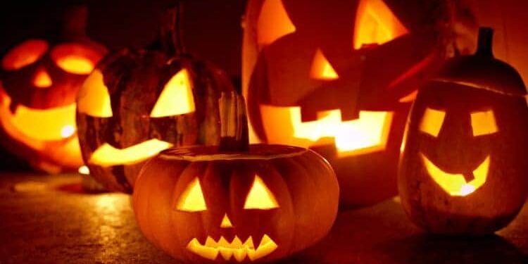 Von innen beleuchtete Kürbislaternen mit gruseligen Fratzen