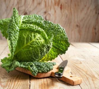 Wirsing-Kohl auf einem Holzbrett nebst Messer