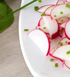 Radieschensalat - In Scheiben geschnittene Radieschen auf weißem Teller