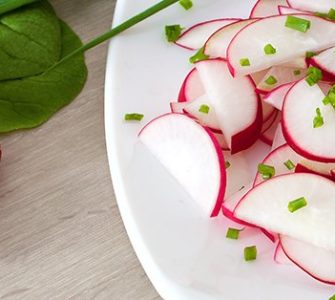 Radieschensalat - In Scheiben geschnittene Radieschen auf weißem Teller