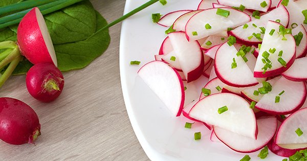 Radieschensalat - In Scheiben geschnittene Radieschen auf weißem Teller