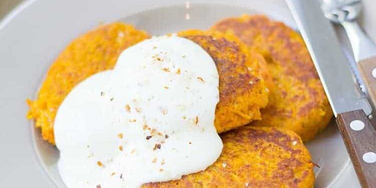 moehren_couscous_bratlinge_750px Drei Möhren-Couscous-Bratlinge mit Quark auf weißem Teller serviert