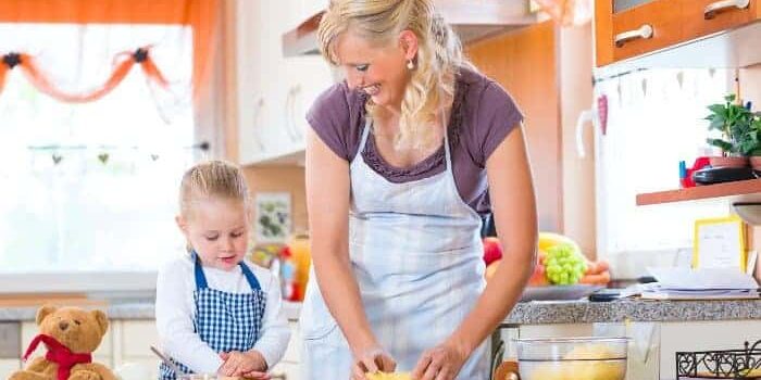 Mutter-Kind-Plätzchenbacken 1 Mutter und Kind mit Schürze backen Plätzchen