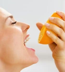 Frau mit einer halben Orange