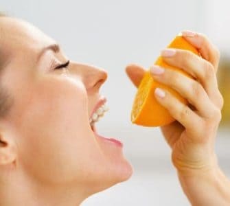Frau mit einer halben Orange