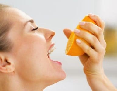 Frau mit einer halben Orange