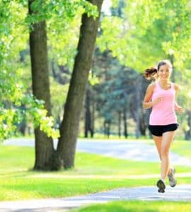 Joggerin läuft durch einen grünen Park