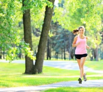 Joggerin läuft durch einen grünen Park