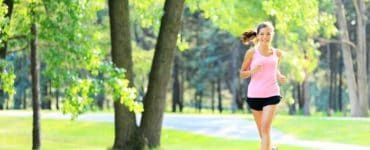 Joggerin läuft durch einen grünen Park