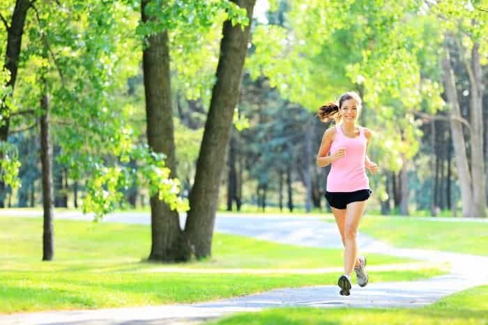 Joggerin läuft durch einen grünen Park