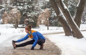 Frau im Schnee dehnt sich.