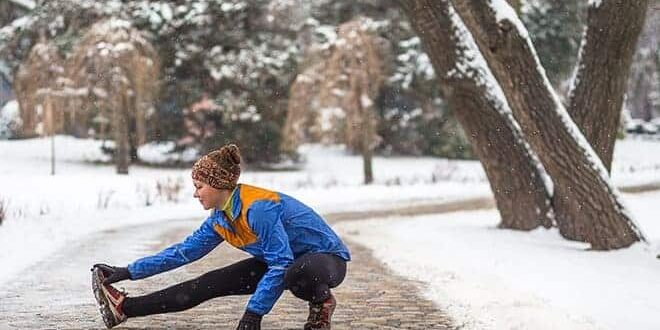 Frau im Schnee dehnt sich.