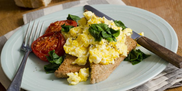 Scheibe Brot mit Rührei und Tomaten