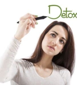 Junge Frau, die das Wort Detox auf eine virtuelle Glasscheibe schreibt