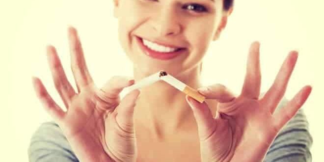 Lächelnde Frau, die eine Zigarette zerbricht