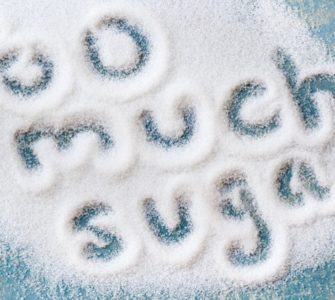 Die Worte Too much sugar geschrieben in eine Fläche ausgestreuten Zuckers