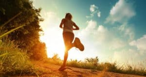 Frau joggt in den Sonnenuntergang.