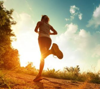 Frau joggt in den Sonnenuntergang.