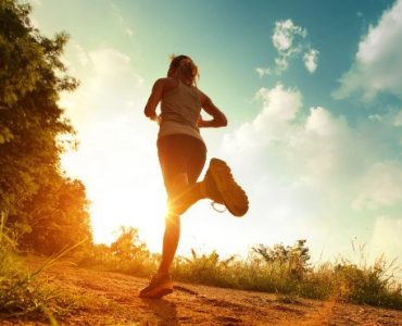 Frau joggt in den Sonnenuntergang.