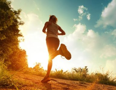 Frau joggt in den Sonnenuntergang.