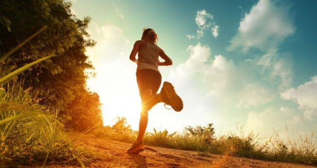 Frau joggt in den Sonnenuntergang.