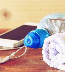 Apfel Kopfhörer Smartphone Handtuchrolle auf Holzoberfläche