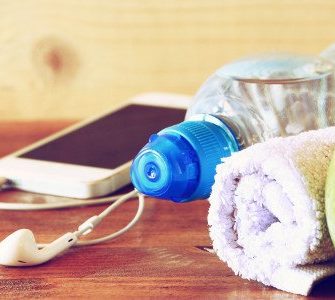 Apfel Kopfhörer Smartphone Handtuchrolle auf Holzoberfläche