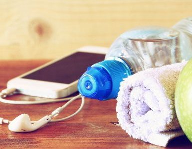 Apfel Kopfhörer Smartphone Handtuchrolle auf Holzoberfläche