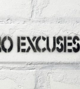 No Excuses Schriftzug auf weißer Backsteinwand.