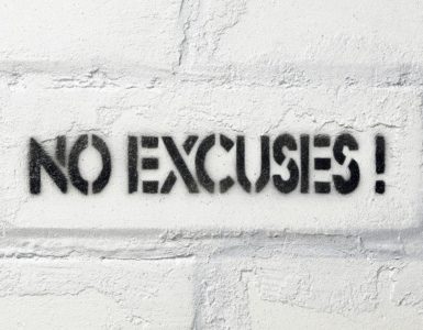 No Excuses Schriftzug auf weißer Backsteinwand.