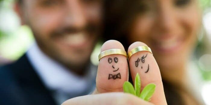 Ehepaar Daumen Eheringe Ehepaar zeeigt Daumen mit aufgesteckem Ehering und Smileys.