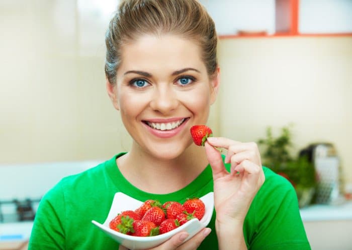 Frau isst eine Schüssel Erdbeeren