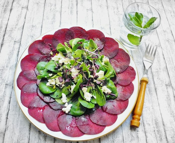 Teller rote beete Scheiben mit Salat in der Mitte