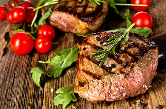 Steak mit Tomaten liegt auf Tisch